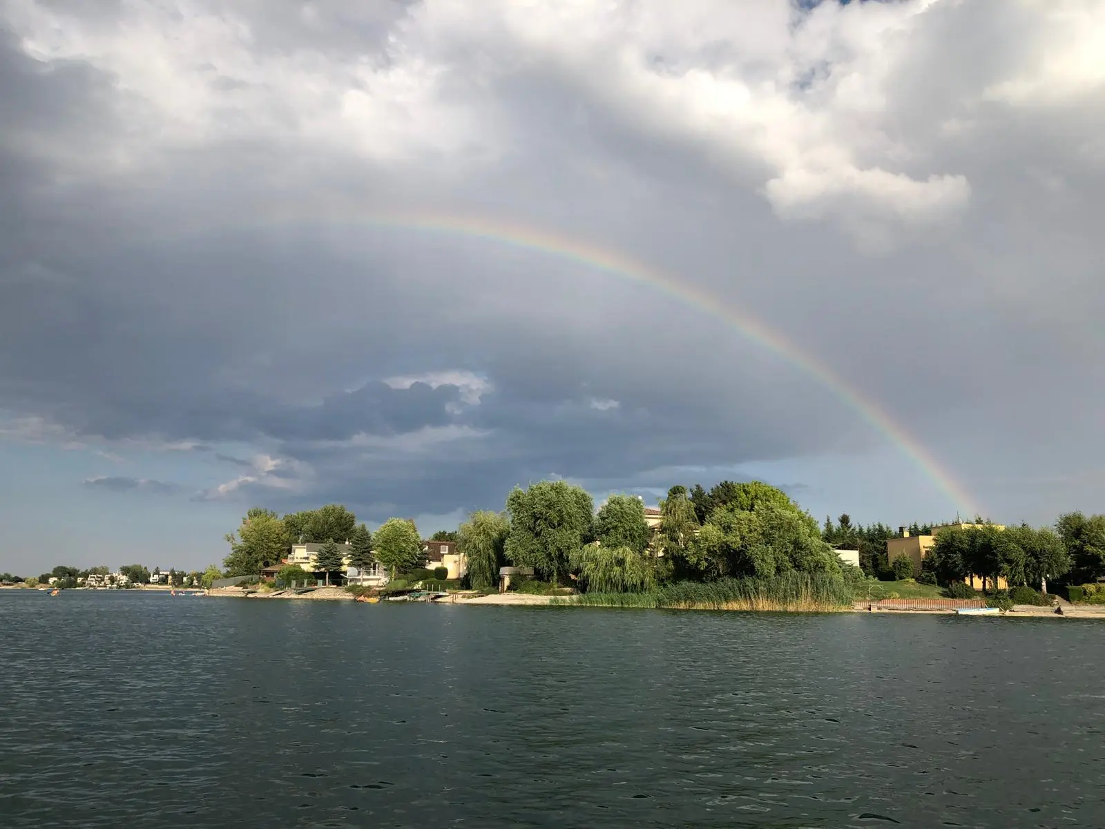 Pokojná hladina Slnečných jazier s dúhou nad horizontom
